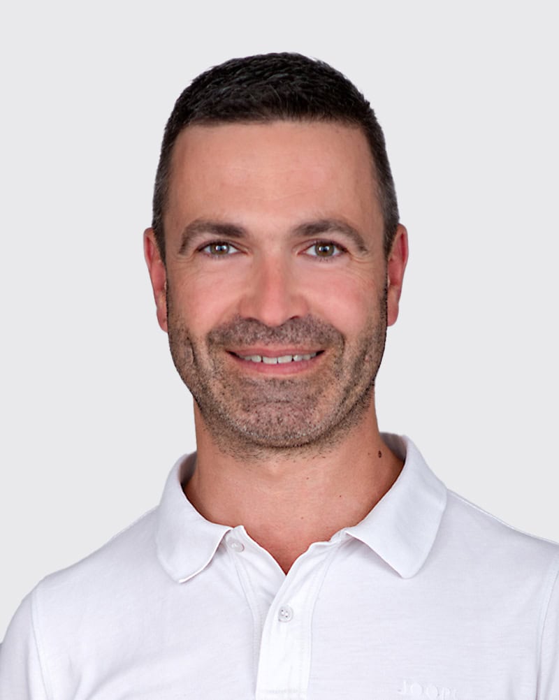 Freundlicher Arzt in weißem Kittel, der Patienten professionell berät, symbolisiert medizinische Kompetenz und Vertrauen.