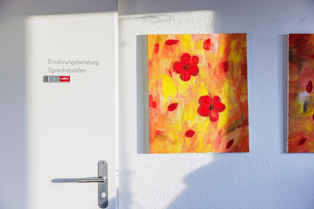 Farbige Blumenmalerei an einer weißen Wand, Teil des Angebots bei Intesto für Ernährungsberatung und Gesundheitsförderung.