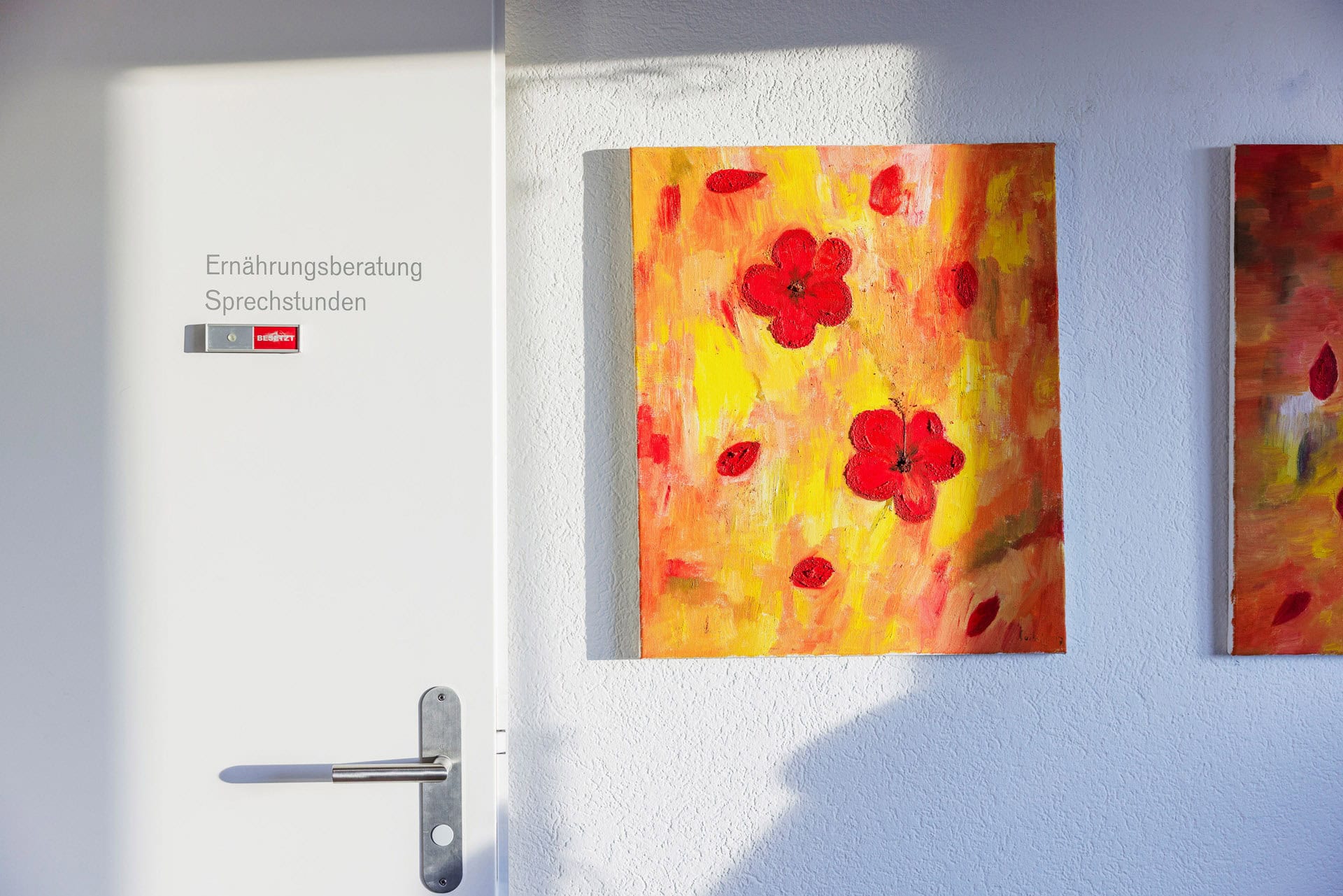 Farbige Blumenmalerei an einer weißen Wand, Teil des Angebots bei Intesto für Ernährungsberatung und Gesundheitsförderung.